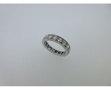 the eighteen round brilliant cut diamonds bead claw set to a plain polished band of unmarked white metal, tests for 18ct whit