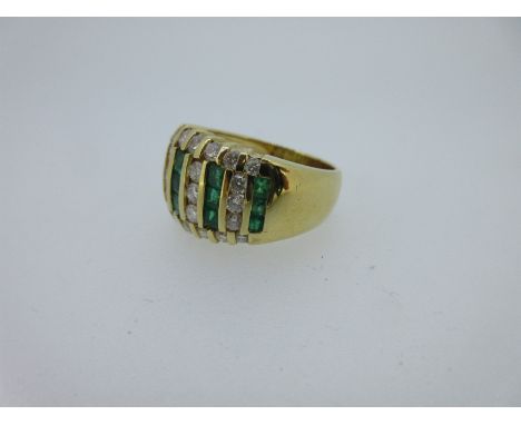 the broad band flaring to the front where five vertical lines of channel set calibré cut emeralds are spaced by lines of roun