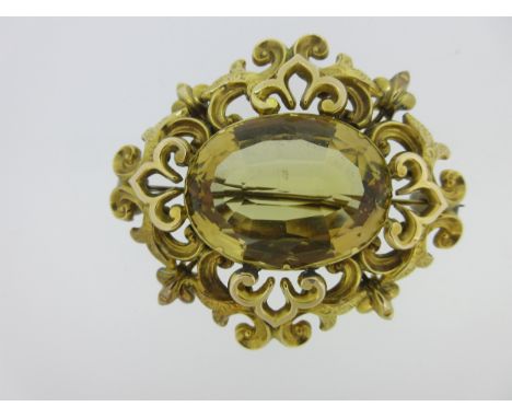 the oval cut citrine claw collet set in an open scrolling and fleur-de-lys mount with bright cut embellishment; length 6.0cm,