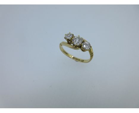 the graduated old round brilliant cut diamonds claw set to a crossover band with diagonally reeded shoulders, ring size O, Ch