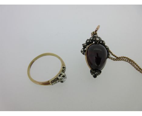 the first with a pear-shaped cabochon garnet in a foiled closed back setting with an open surmount of trailing leaves and flo