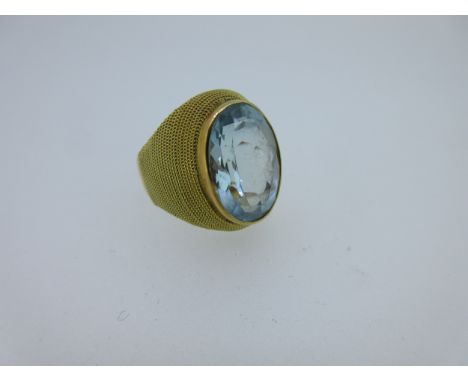 the oval cut aquamarine measuring approximately 15.5 x 10.7mm, in a polished collet to a tapered mount of concentric ropetwis
