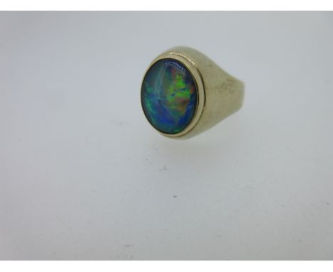 styled as a signet ring and collet set with an oval low cabochon black opal displaying vivid and varied play of colour, predo