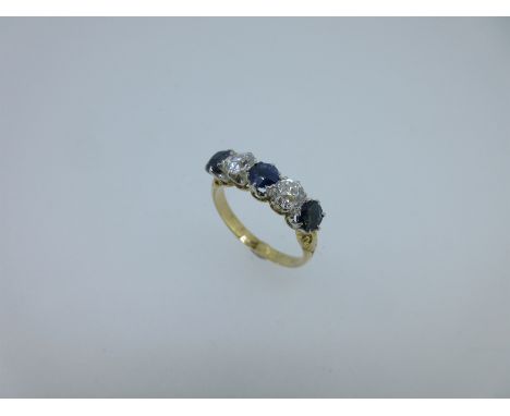 the two old round brilliant cut diamonds separated by a round cut sapphire with an oval cut sapphire at either end, claw set,