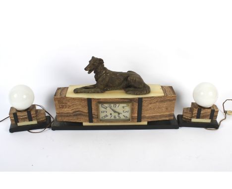 A French Art Deco alabaster and marble three piece clock garniture. The canted rectangular clock case surmounted with a bronz