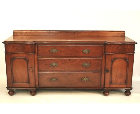 A Victorian mahogany sideboard. The galleried moulded top above three central long graduated drawers with pierced brass handl