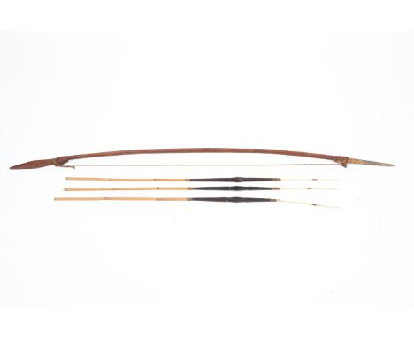 A Solomon Islands hunting bow and arrows with carved bone heads. Bow L149cm, arrows L105cm Condition Report: Overall in good 