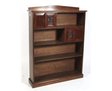 An Edwardian mahogany free standing open bookcase. With gallery rail and later added upper and lower two door cupboards raise