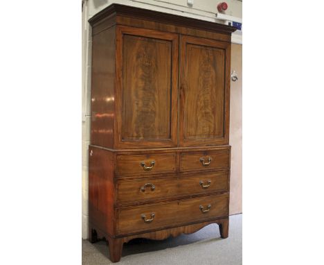 A Victorian flame mahogany linen press. The upper section with ebonised inlay to the paneled doors. Enclosing five internal s