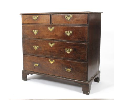 A Georgian oak chest of drawers. With two short over three long drawers, with shaped beading and raised on bracket supports. 