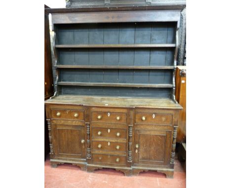 AN ANGLESEY OAK BREAKFRONT DRESSER, the three shelf backed boarded rack with inlaid diamond and star frieze decoration and sh