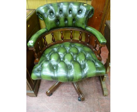 AN ANTIQUE STYLE CAPTAIN'S CHAIR in green button back leather effect upholstery, with a curved spindle back gallery on a swiv