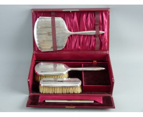 A CASED HALLMARKED SILVER FOUR PIECE DRESSING TABLE SET of hand mirror, brushes and comb, Birmingham 1932