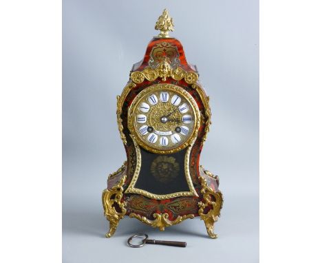 A FRENCH BOULLE MANTEL CLOCK of waisted form with gilt metal mounts and brass inlay on red tortoiseshell, the gilt dial set w