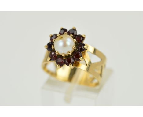 A 9CT GOLD CULTURED PEARL AND GARNET CLUSTER RING, designed as a central cultured pearl bead within a circular garnet cluster