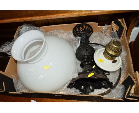 A LATE 19TH CENTURY WROUGHT IRON OIL LAMP, with a white ceramic reservoir and glass shade