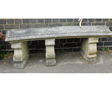 A reconstituted stone curved garden bench, the rectangular curved top on three scroll plinths, 49cm high, 143cm wide, 40cm de