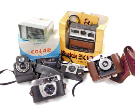 A group of camera equipment, to include a Kodak instant camera, a ful-vue box camera, a Pentax flash, Helina and a Kodak inst