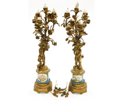 A pair of 19thC French ormolu candelabra, each with four branch candle holders and foliate ornamentation on figural cherub co