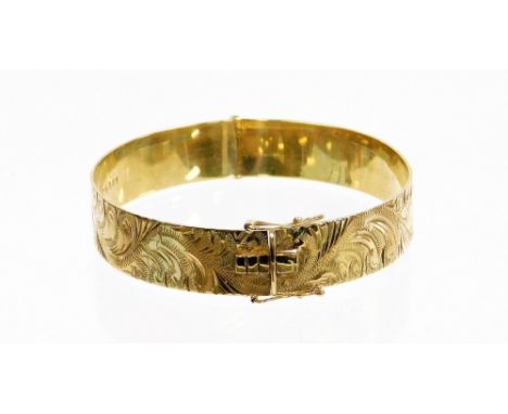 A 9ct gold hinged bangle, with etched floral design, and safety clasp, 6.5cm wide, 21.8g.