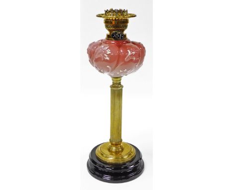 A Victorian opaque glass oil lamp, on a brass column, with pink floral reservoir on a stepped ebonised black base, 49cm high.