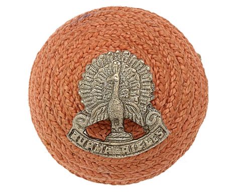 Indian Army. Burma Rifles Officer’s cord boss.Pinky red cord boss mounted with silvered peacock on title scroll.  Wires Sligh