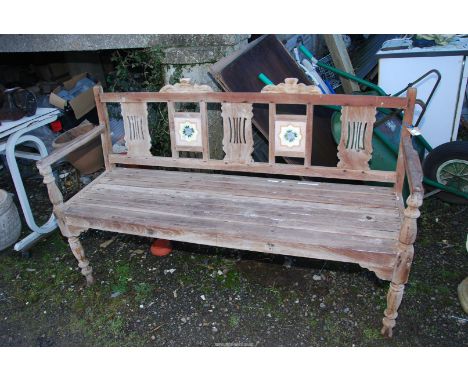 A pine garden bench having two tile inserts to the back, 5' long x 19 1/2" deep x 3' high.