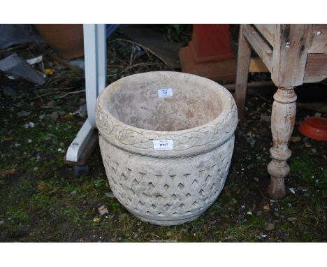 A concrete planter having lattice decoration, 12" diameter x 12" high.