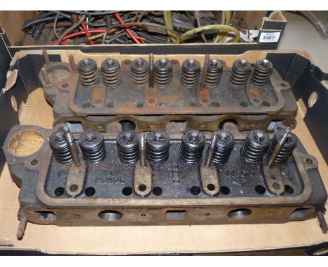 Two Engine Cylinder Heads with valves and valve springs installed.