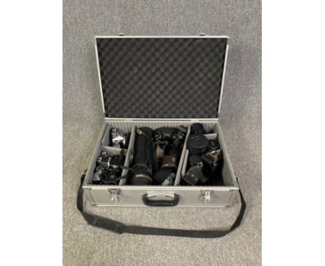 A hard case containing four Minolta 35mm SLR cameras together with a selection of lenses by Hoya, Vivitar and a telephoto Sol