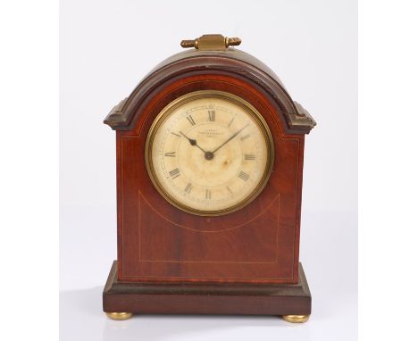 Edwardian mahogany and boxwood strung mantel clock the arched case with brass carrying handle, the dial with retailers name M