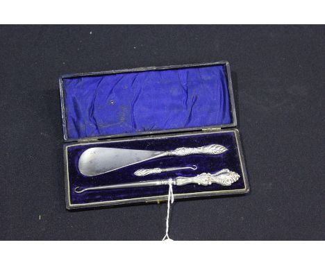 Silver handled shoe horn, non-contemporary large and small button hooks, housed in a fitted case