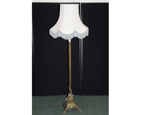 Edwardian brass standard lamp, of column form with reeded stem, on a stepped wreath decorated foot and brass paw feet