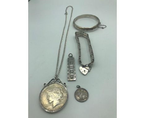 A Lot of silver jewellery which includes Liberty 1924 silver one dollar coin with silver chain, Birmingham silver ingot penda