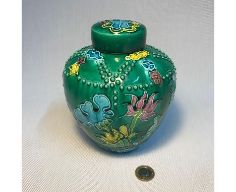 A Chinese enamel painted preserve pot, depicting raised designed flowers, beads and birds. Has a Kangxi mark to the base. Mea