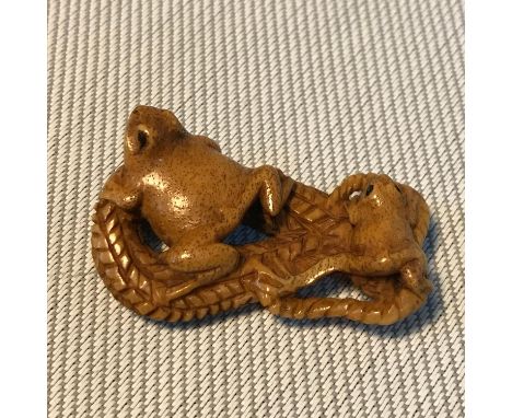 A Japanese hand carved netsuke double frog figure, Signed by the artist. Measures 4cm in length 