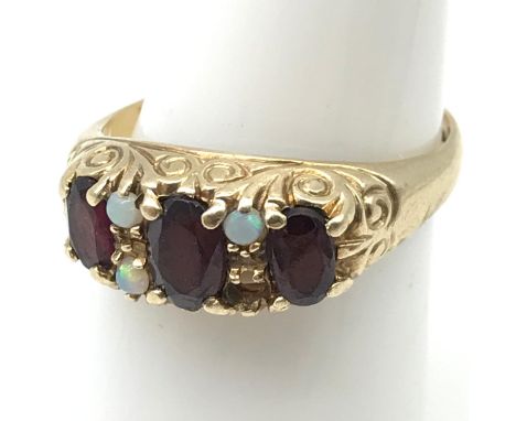 A Ladies antique 9ct gold ring set with 3 large garnets and 3 small opals. (Missing one opal) Ring size N. Weighs 3.32grams 