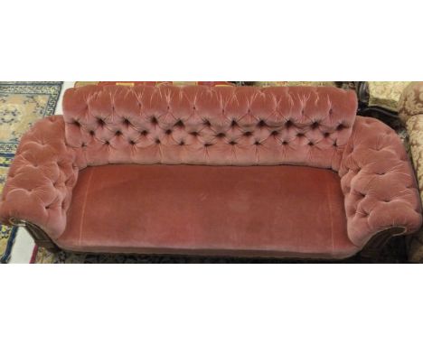 A Victorian button back scroll arm sofa with oak show frame to turned legs, upholstered in rose coloured velvet fabric