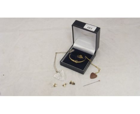 A Goldsmiths box containing a yellow metal bangle with clear stones, two pairs of pearl ear studs, a heart shaped stone penda