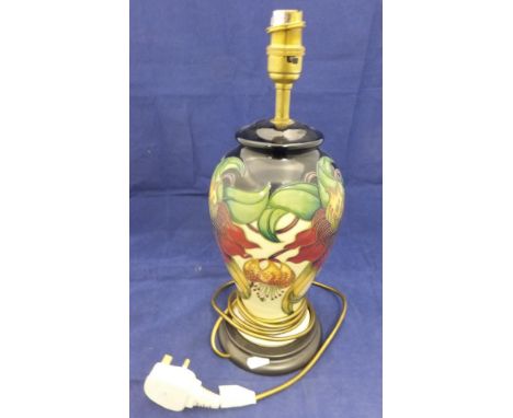A Moorcroft Pottery table lamp decorated with lilies in red and orange on a cream ground, together with a cream shade CONDITI