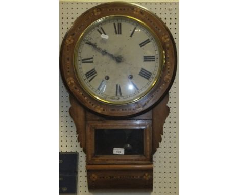 A walnut and inlaid drop dial wall clock, the rounded enamel face bearing Roman numerals