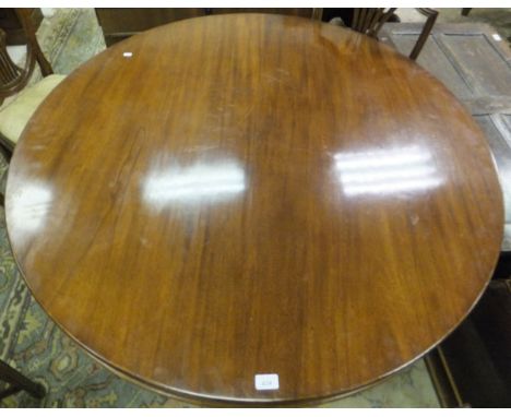 An early 19th century circular breakfast table, raised on pedestal to tripod base and brass lion's paw caps and castors