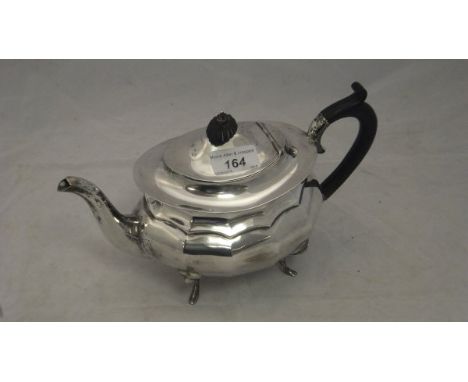 A silver teapot of faceted form with ebony handle and finial, raised on four swept feet (Birmingham, 1922), approx 17.5 oz in