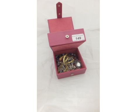 A pink jewellery box containing a collection of costume jewellery to include necklaces, earrings, etc, together with a collec