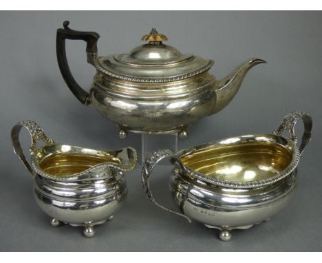 A regency silver matched three-piece tea service of oval form with silver-gilt interiors &amp; gadrooned rims, the open loop 