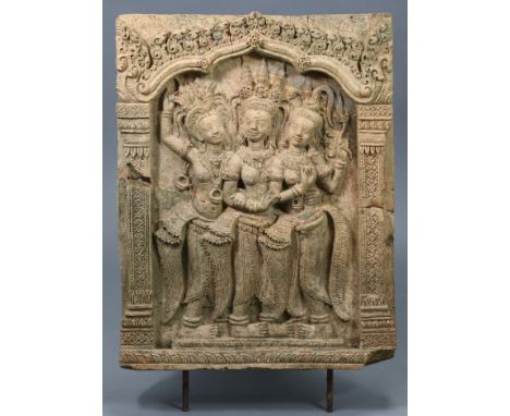 An Indian terracotta relief-decorated rectangular tile depicting three dancing figures in an ornate archway; 23” x 16”.