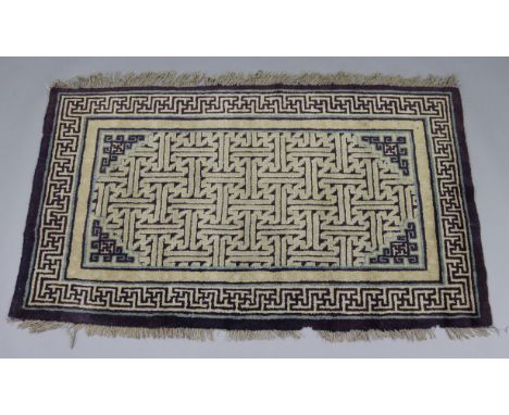 A Chinese small rug of cream ground, with repeating geometric designs in aubergine &amp; light blue borders; 3’2” x 5’2”.