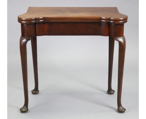 A GEORGE II ‘RED WALNUT’ CARD TABLE, the rectangular fold-over top with protruding rounded corners, the baize-lined interior 