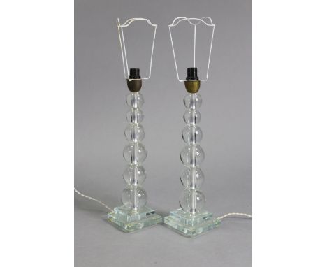 A pair of 20th century Italian clear glass table lamps on graduated ‘bobbin’ columns &amp; square bases, 18” high.