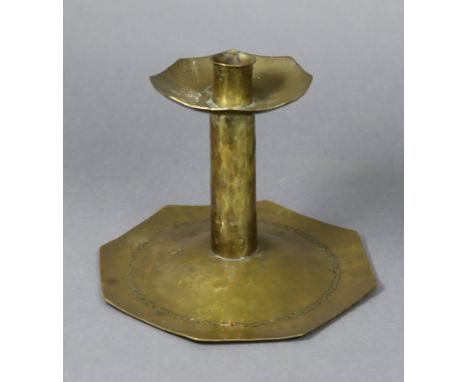 An Arts &amp; Crafts brass candlestick of octagonal form, with planished surface &amp; engraved decoration to the slightly do